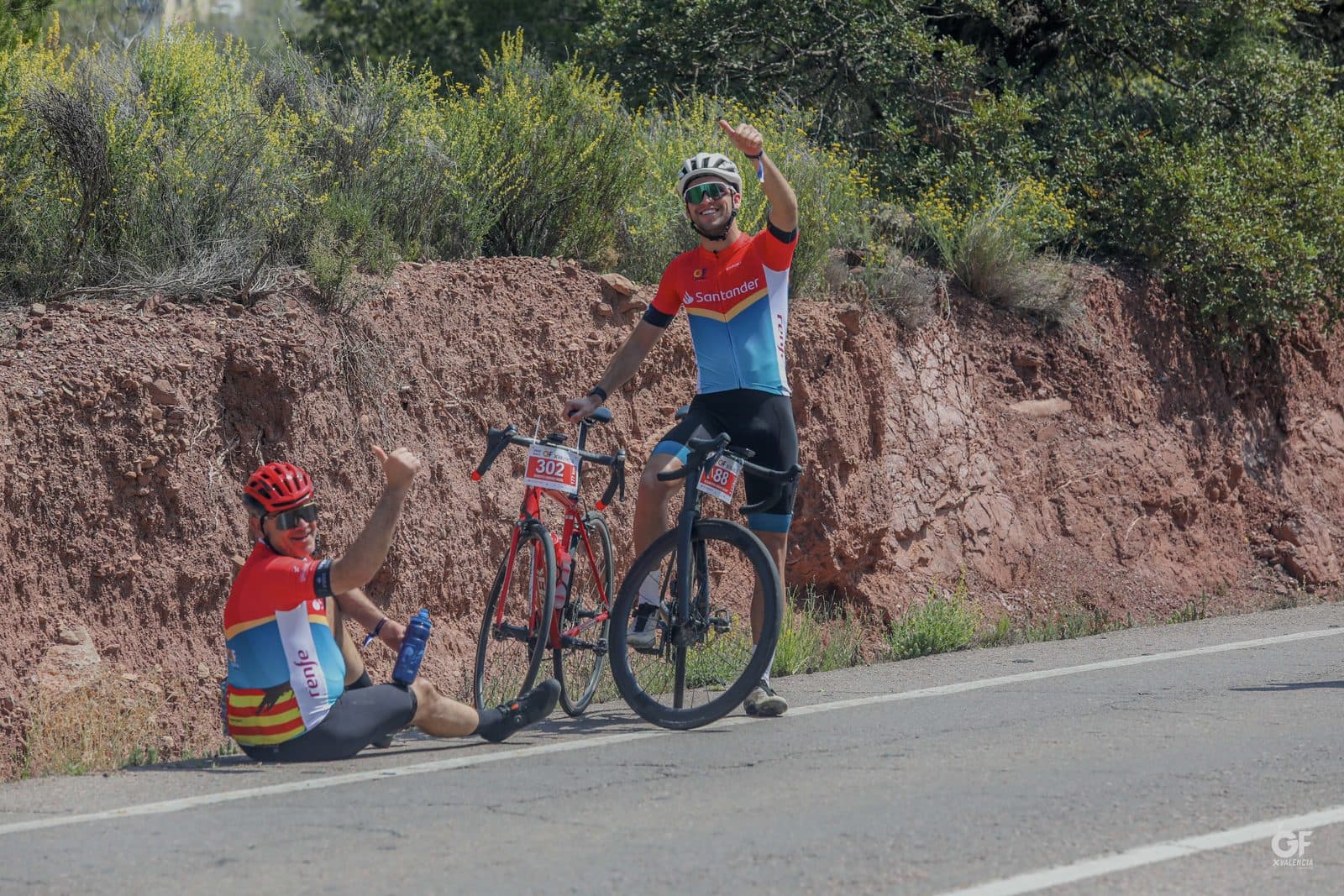 Dos ciclistas parados a un lado de la carretera durante una salida