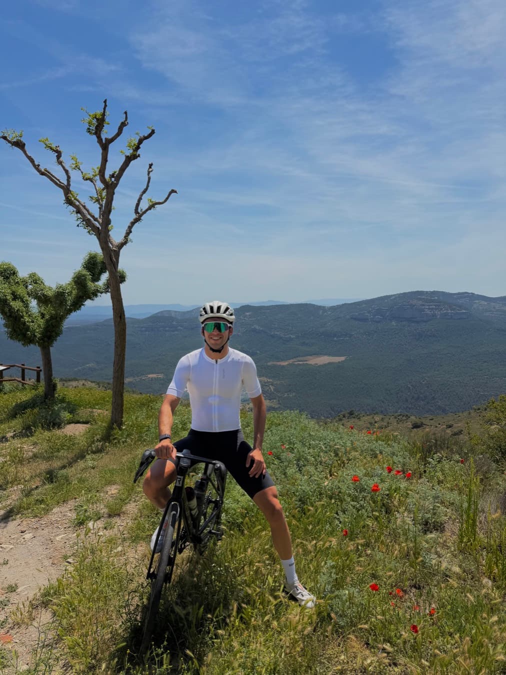Alejandro de pie junto a su bici en lo alto de un mirador de montaña